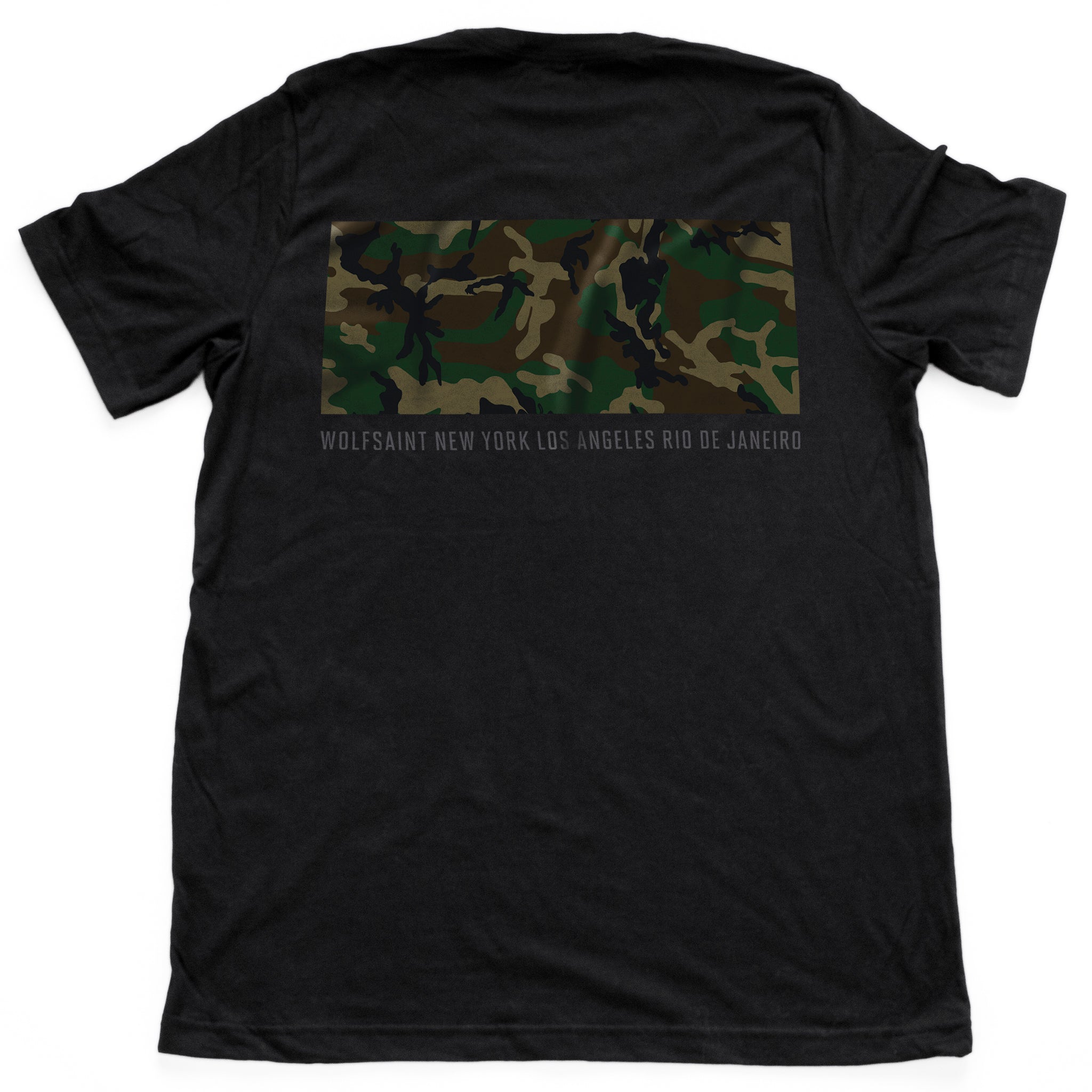 The back side of a fashionable black t-shirt with a camo / camouflage panel on both sides. On the front there is also a Wolfsaint script logo within the camo panel; on the reverse are the Wolfsaint cities “New York, Rio de Janeiro, Los Angeles” listed innsmaller type below the camouflage. From Wolfsaint.net