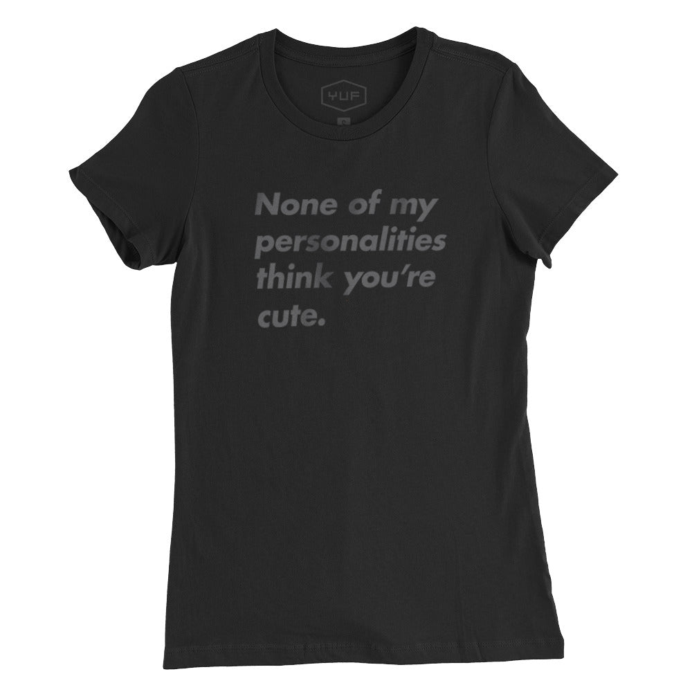 A sarcastic women’s graphic t-shirt in black, with the text “None of my personalities think you’re cute.” By fashion brand YUF, from wolfsaint.net