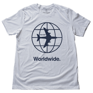 A GIF showing the front and back of black and white versions of a fashion t-shirt representing a jetsetting lifestyle. On the front of the shirts is a simple graphic of a commercial airliner superimposed on a globe, and the word “Worldwide.” On the reverse is a stack of airport codes representing international travel (New York/JFK, Los Angeles/LAX; Rio de Janeiro/GIG; San Jose Costa Rica/SJO; Tokyo/NRT; Paris/CDG). By fashion brand WOLFSAINT, from wolfsaint.net