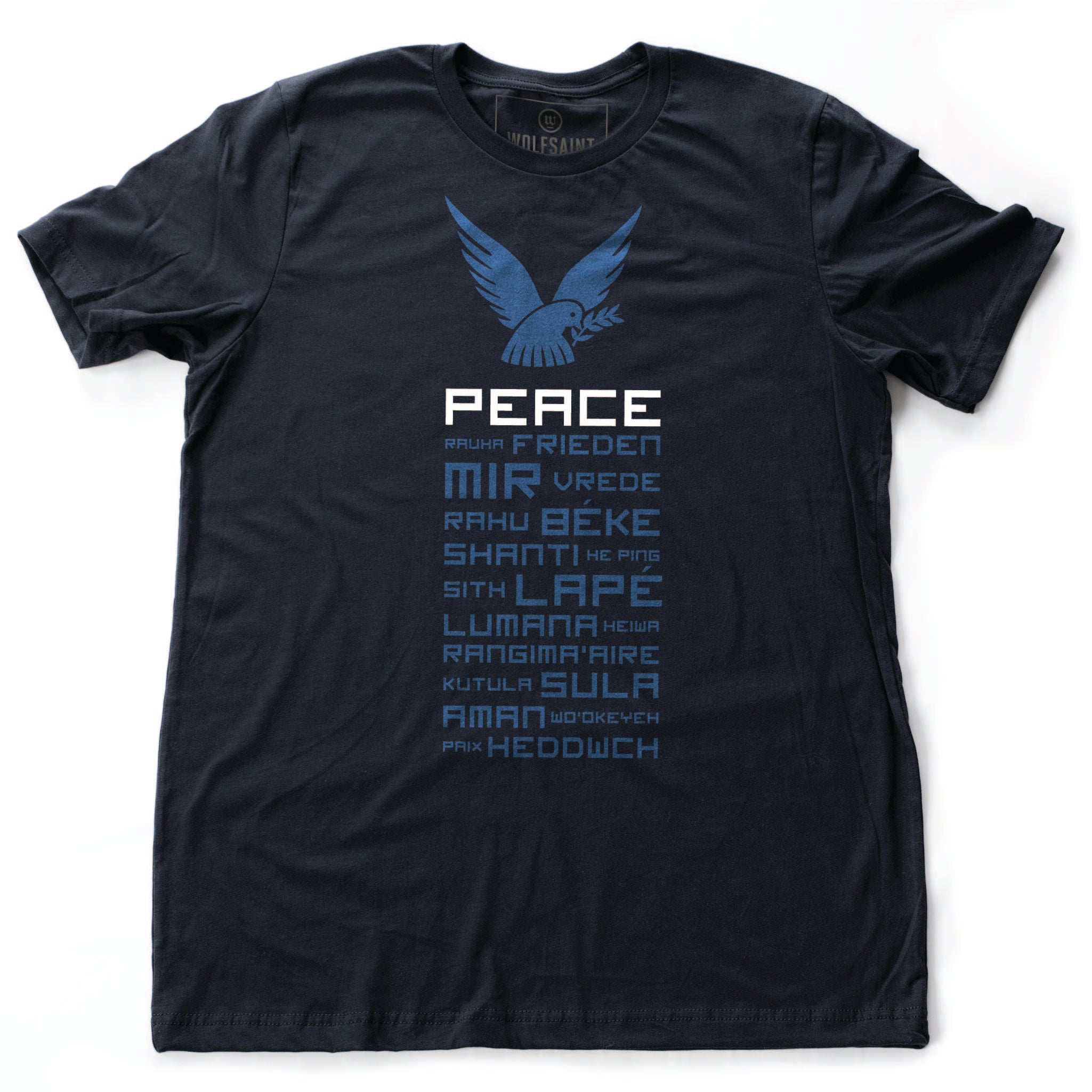 A classic retro graphic t-shirt in navy Blue, featuring a dove above the word “PEACE.” Below, are the words for Peace in multiple languages from around the world. By fashion brand Wolfsaint, available at wolfsaint.net
