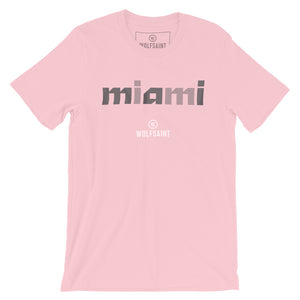 A stylish fashion-shirt in ‘south beach pink,’ with a colorful graphic modern typographic treatment of “miami” in Gray crosshatched lowercase letters, with the Wolfsaint logo beneath it. From wolfsaint.net