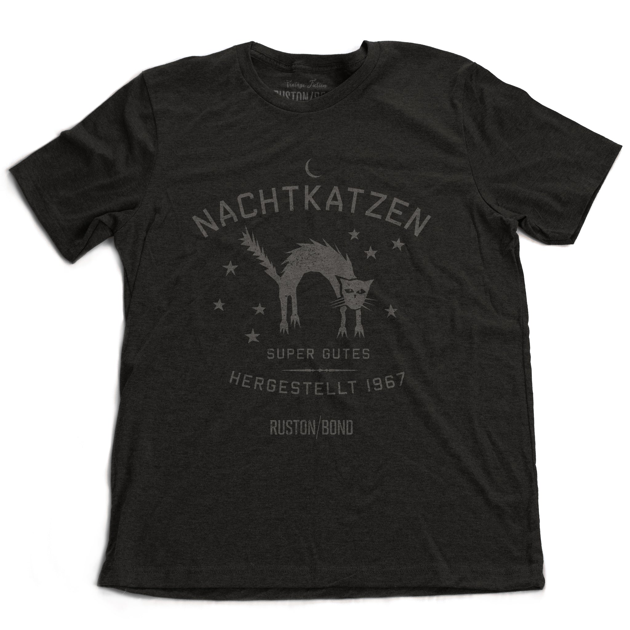A vintage-inspired retro design graphic t-shirt in Dark Gray Heather, featuring the image of an arched cat among stars, and the German text “NACHTKATZEN, Super Gutes” — translating to “Night Cats, super good” and the year 1967, with the Ruston/Bond logo beneath. From wolfsaint.net