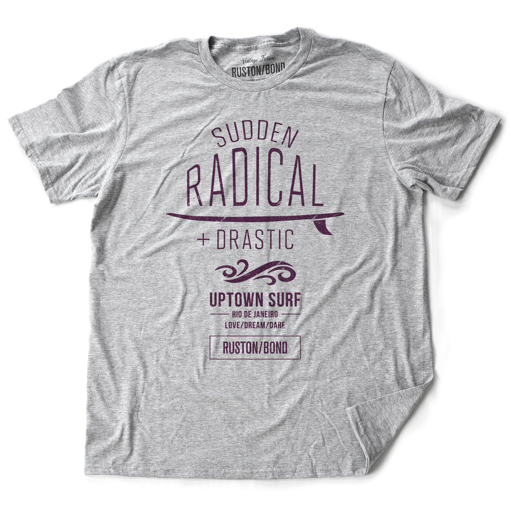 A stylish retro graphic t-shirt for UPTOWN SURF, featuring a surfboard and the words “Sudden Radical Drastic” by fashion brand RUSTON/BOND, for Wolfsaint.net
