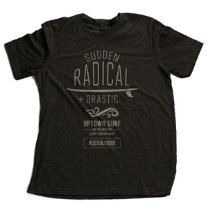 A stylish retro graphic t-shirt for UPTOWN SURF, featuring a surfboard and the words “Sudden Radical Drastic” by fashion brand RUSTON/BOND, for Wolfsaint.net