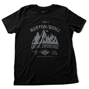 Black and 'silver'  classic, fashion, retro inspired t-shirt, with a fictional advertisement for an adventure company called Ruston/Bond Arctic Expeditions. It shows a mountain range and a helicopter, and lists the company locations in New York City and Ixelles, Belgium, and a Latin quote.  Inspired by the films of Wes Anderson. From wolfsaint.net