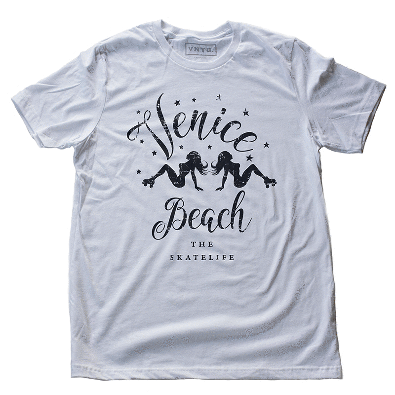 A vintage-inspired, retro graphic t-shirt featuring the silhouettes of sexy female roller skaters, a back to back mirror image, and the words “Venice Beach” in large script above and below, plus the words “the skatelife” at the bottom. By fashion brand VNTG., from wolfsaint.net
