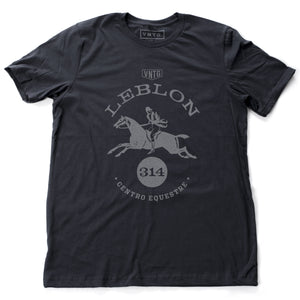 A preppy fashion retro, vintage-inspired t-shirt in classic Navy Blue, featuring a leaping horse in dressage competition, surrounded by the words “Leblon Centro Equestre” (Leblon Equestrian Center) a fictitious horse training and competition facility in Rio de Janeiro, Brazil. By fashion brand VNTG., for wolfsaint.net