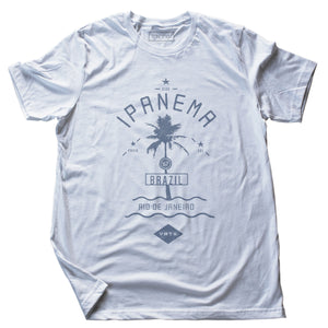 A vintage-inspired, Classic retro t-shirt in White with faded blue, featuring a graphic of a single palm tree over waves, as a tourism promotion for Ipanema beach, in Rio de Janeiro, Brazil. By fashion brand VNTG., from Wolfsaint.net