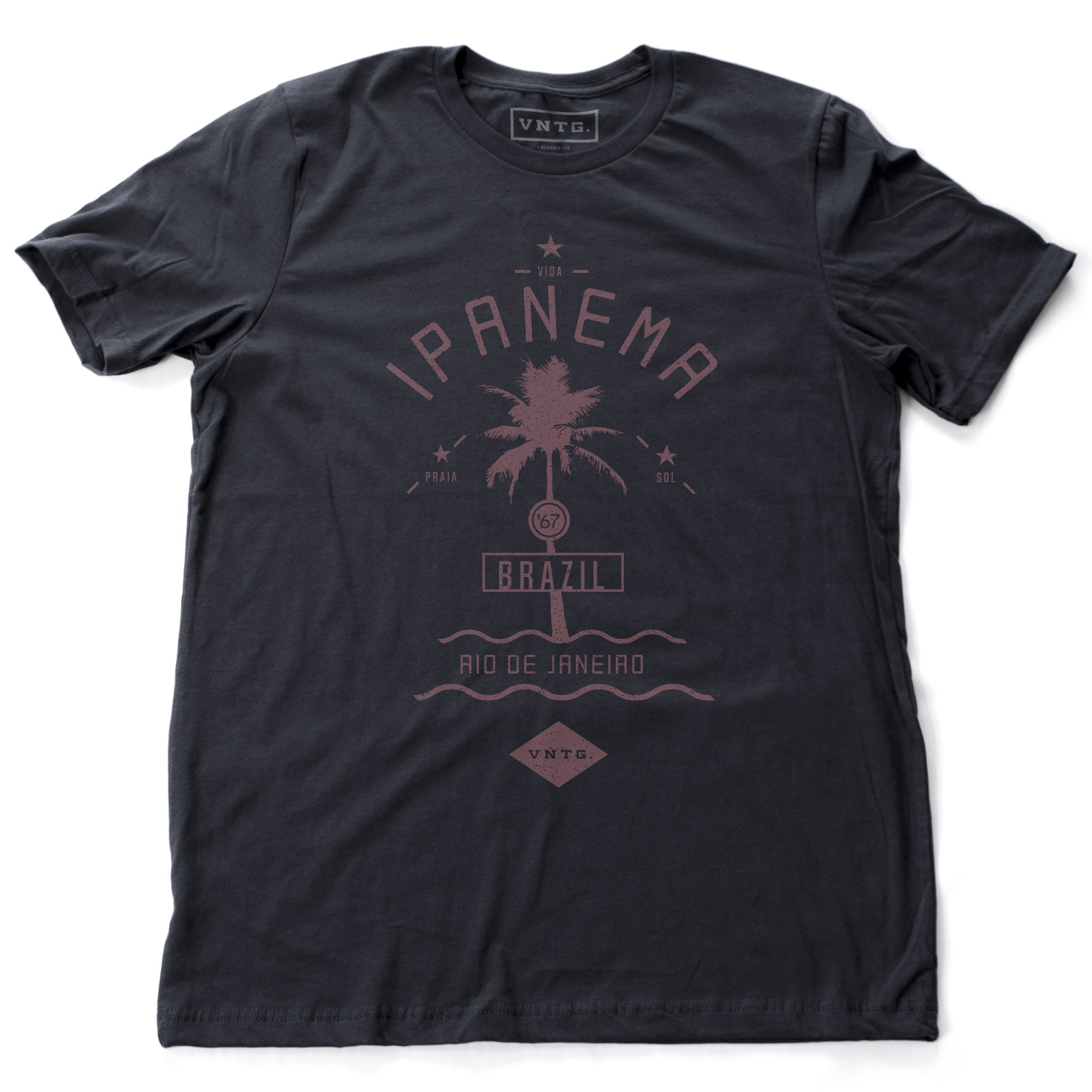 A vintage-inspired, Classic retro t-shirt in Navy Blue, featuring a graphic of a single palm tree over waves, as a tourism promotion for Ipanema beach, in Rio de Janeiro, Brazil. By fashion brand VNTG., from Wolfsaint.net