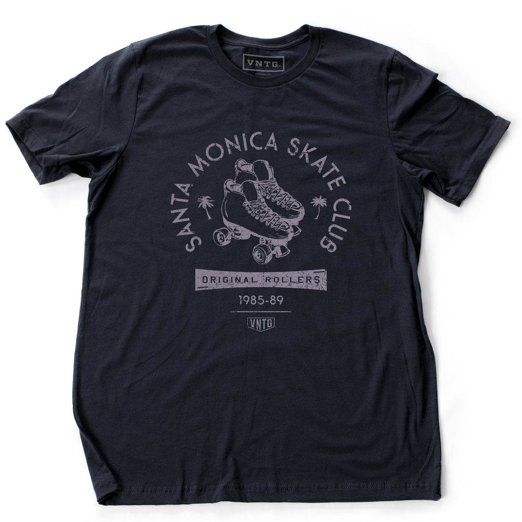 A vintage-inspired Navy Blue retro t-shirt for the fictitious Santa Monica Skate Club, “original rollers 1985-89” featuring a pair of quad roller skates and palm trees. By fashion brand VNTG. for Wolfsaint.net