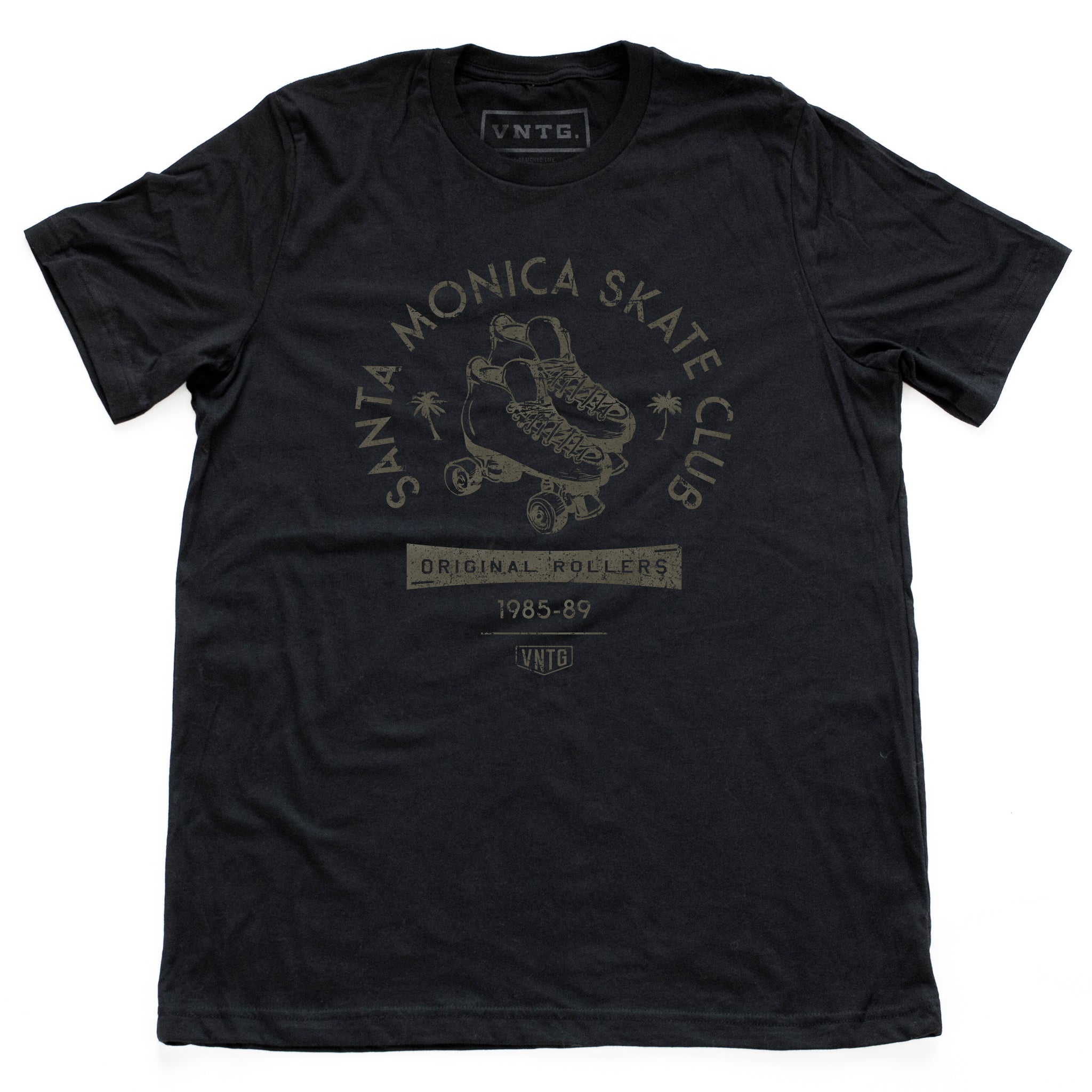 A vintage-inspired retro t-shirt in classic Black for the fictitious Santa Monica Skate Club, “original rollers 1985-89” featuring a pair of quad roller skates and palm trees. By fashion brand VNTG. for Wolfsaint.net