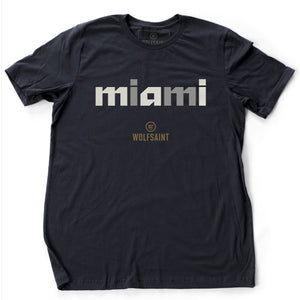 A stylish fashion-shirt in Classic Navy Blue, with a graphic modern typographic treatment of “miami” crosshatched lowercase letters, with the Wolfsaint logo beneath it. From wolfsaint.net
