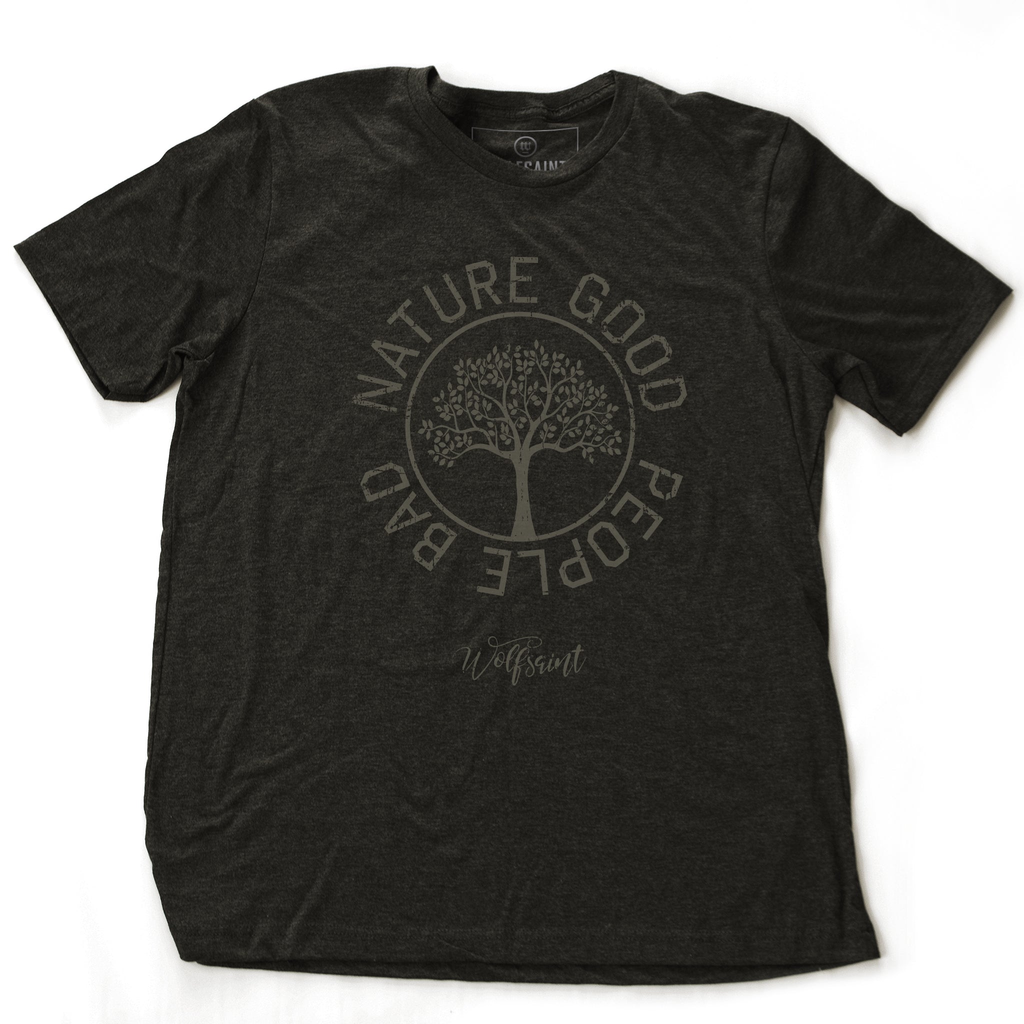 A fashionable vintage-inspired, retro t-shirt in Dark Heather Gray, featuring a graphic of a thriving tree in a circle, surrounded by the sarcastic text: “NATURE GOOD, PEOPLE BAD” with the Wolfsaint brand script logo beneath. From wolfsaint.net