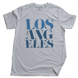 A fashionable white graphic t-shirt featuring the word “LOS ANGELES” in a elegant font, stacked in three tilted lines to sarcastically simulate an earthquake. From wolfsaint.net