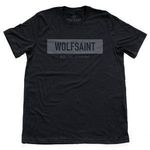 A simple fashion-branded black t-shirt with the WOLFSAINT gothic logo in a gray rectangle, and “Rio de Janeiro” in smaller type below. From Wolfsaint.net