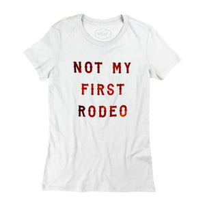 A Ladies cut sarcastic graphic t-shirt in White, with custom vintage retro typography, reading “Not my first rodeo” — BY fashion brand YUF, from wolfsaint.net
