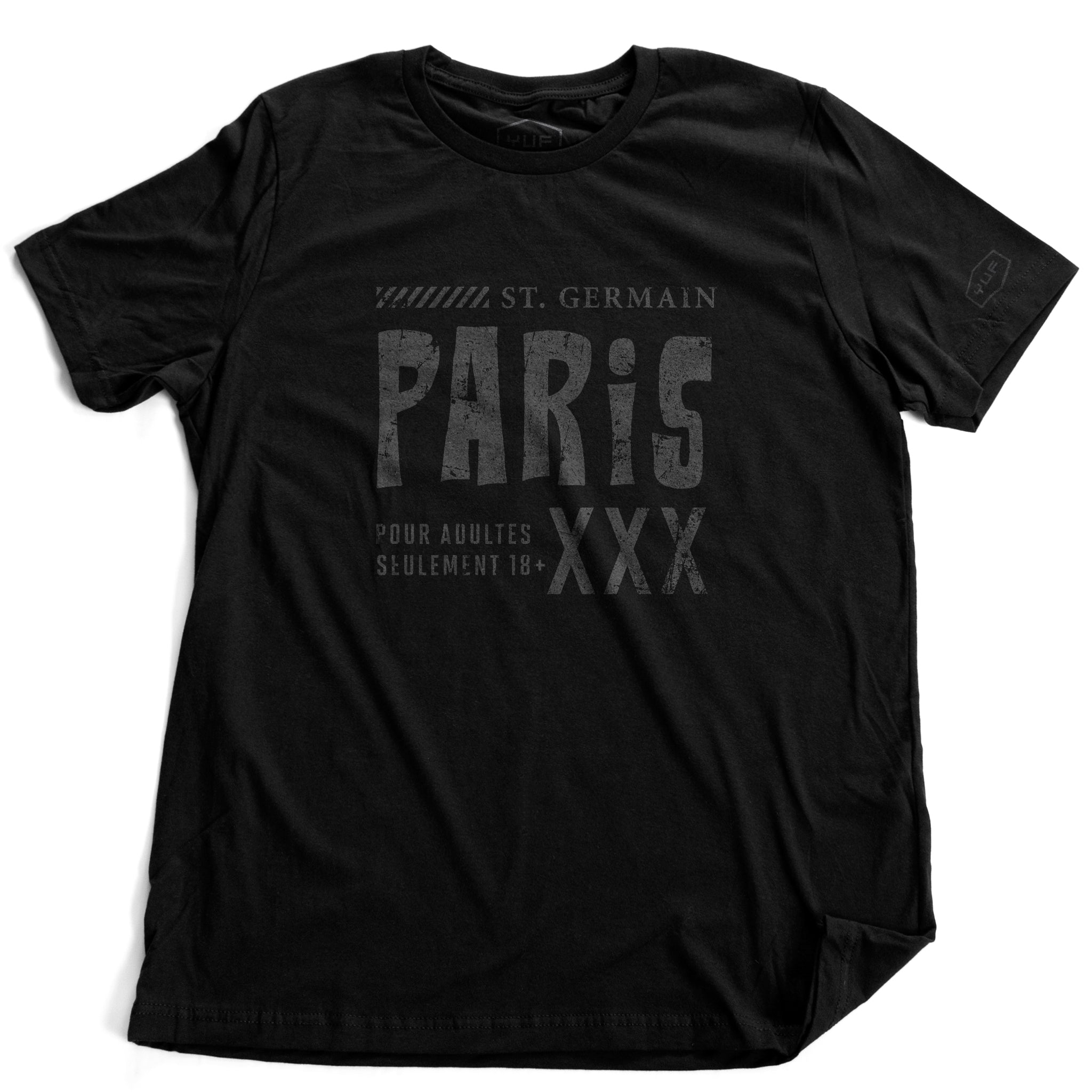A fashionable, vintage-inspired retro graphic t-shirt in Classic Black. On the shirt is a sarcastic promotion of the adult entertainment district in St. Germain, with the large word “PARIS” and “XXX” most prominent. By fashion brand YUF. From wolfsaint.net