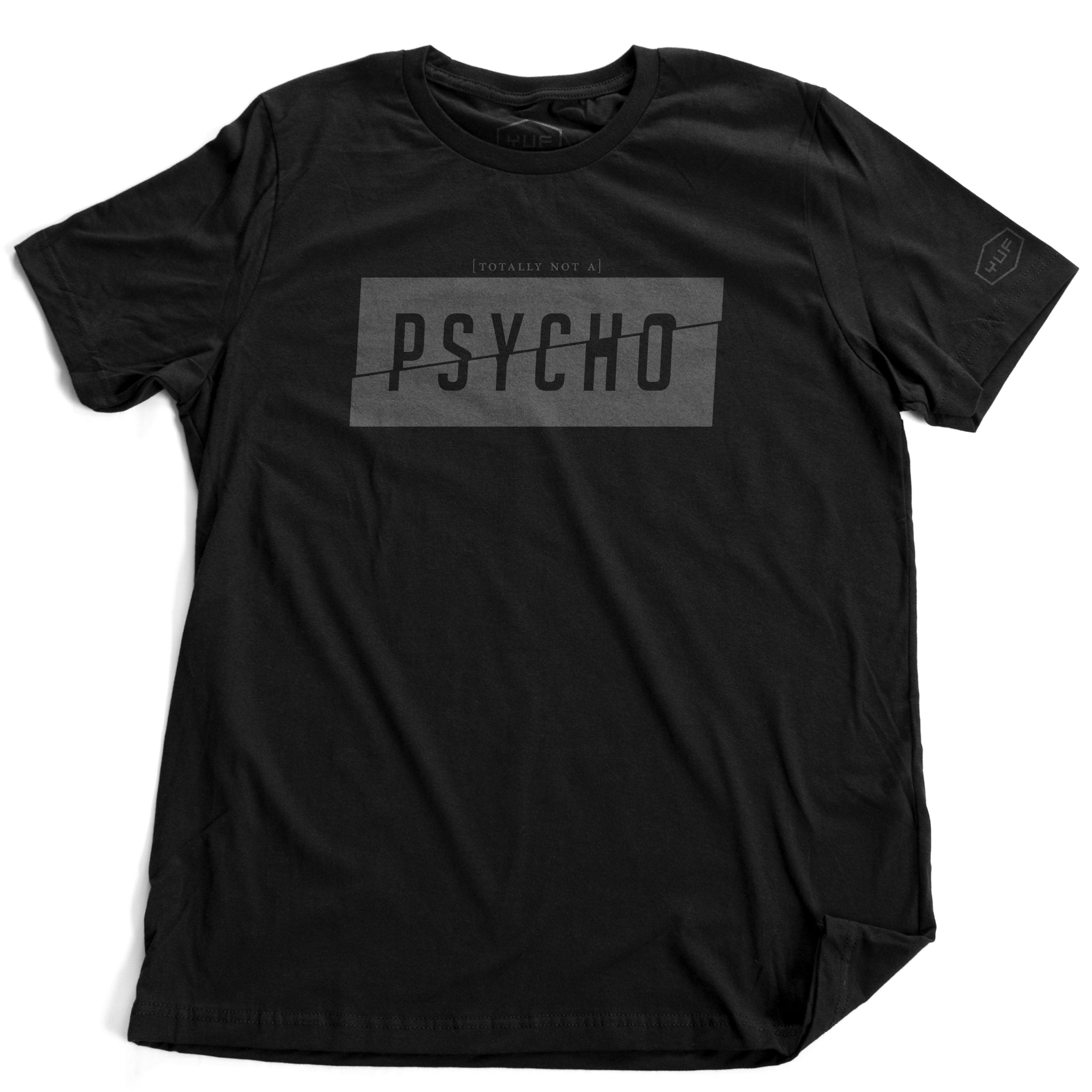 A sarcastic fashion t-shirt in black, featuring a graphic with the word “PSYCHO” split in half diagonally, within a rectangle, to represent a ‘fractured’ personality. Above the box are the words “totally not a...” in a much smaller font. From fashion brand YUF, available on wolfsaint.net