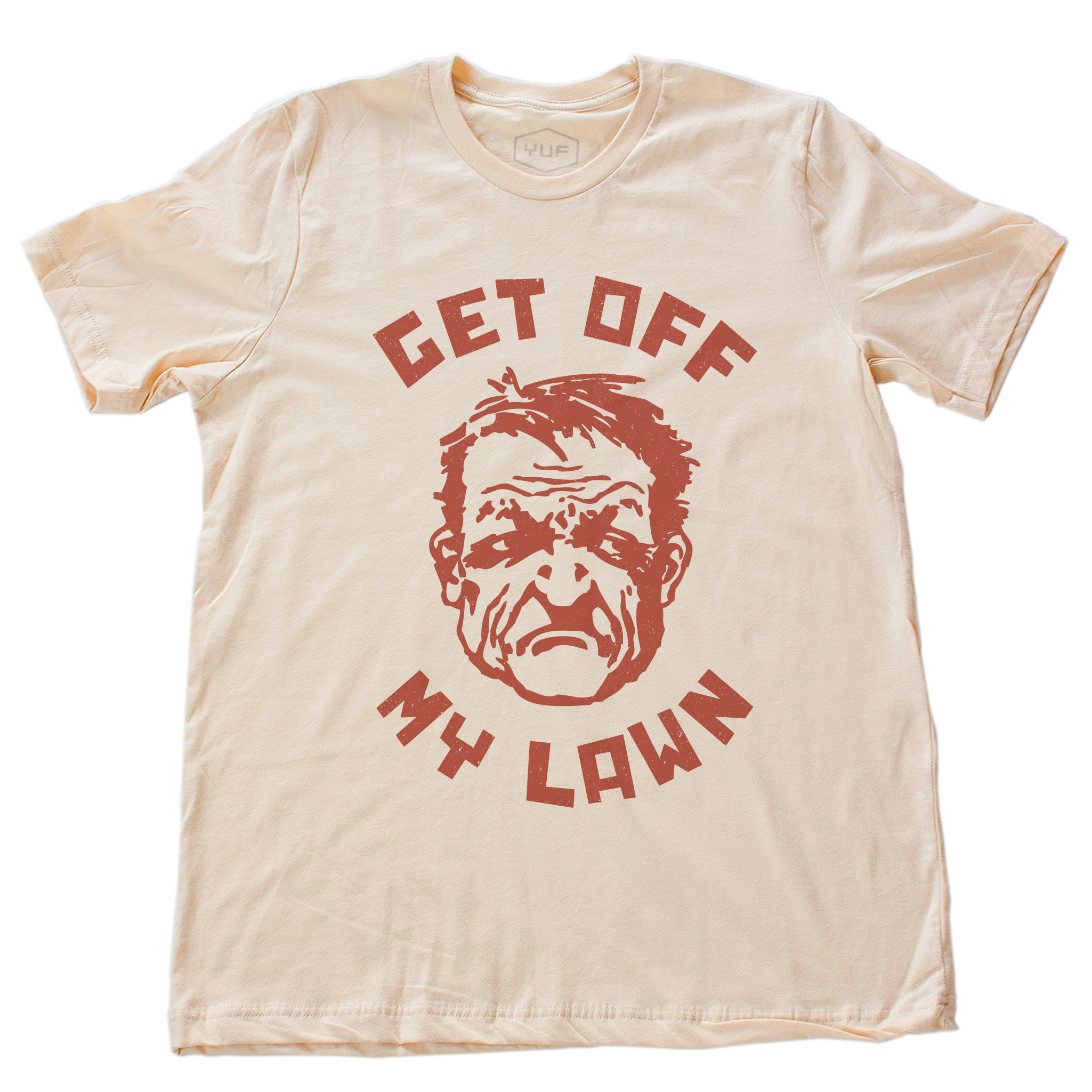 A sarcastic t-shirt in Soft Cream, inspired by the “Get Off My Lawn” meme, featuring a cartoonish angry man and bold typography. From fashion brand YUF, available at wolfsaint.net