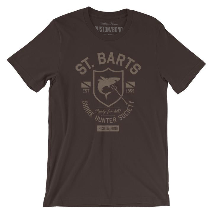 A vintage-inspired, retro design graphic t-shirt with sarcastic fictitious art, featuring a shark within a shield, for the imaginary St Bart’s Shark Hunter Society. By fashion brand Ruston/Bond, for wolfsaint.net