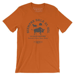 A Classic fashion t-shirt celebrating Ernest Hemingway’s novel “THE SUN ALSO RISES,” in its Spanish language translation. It reads “SIEMORE SALE EL SOL” around the image of two bulls, and “la rice gauche.” By fashion brand VNTG., from wolfsaint.net