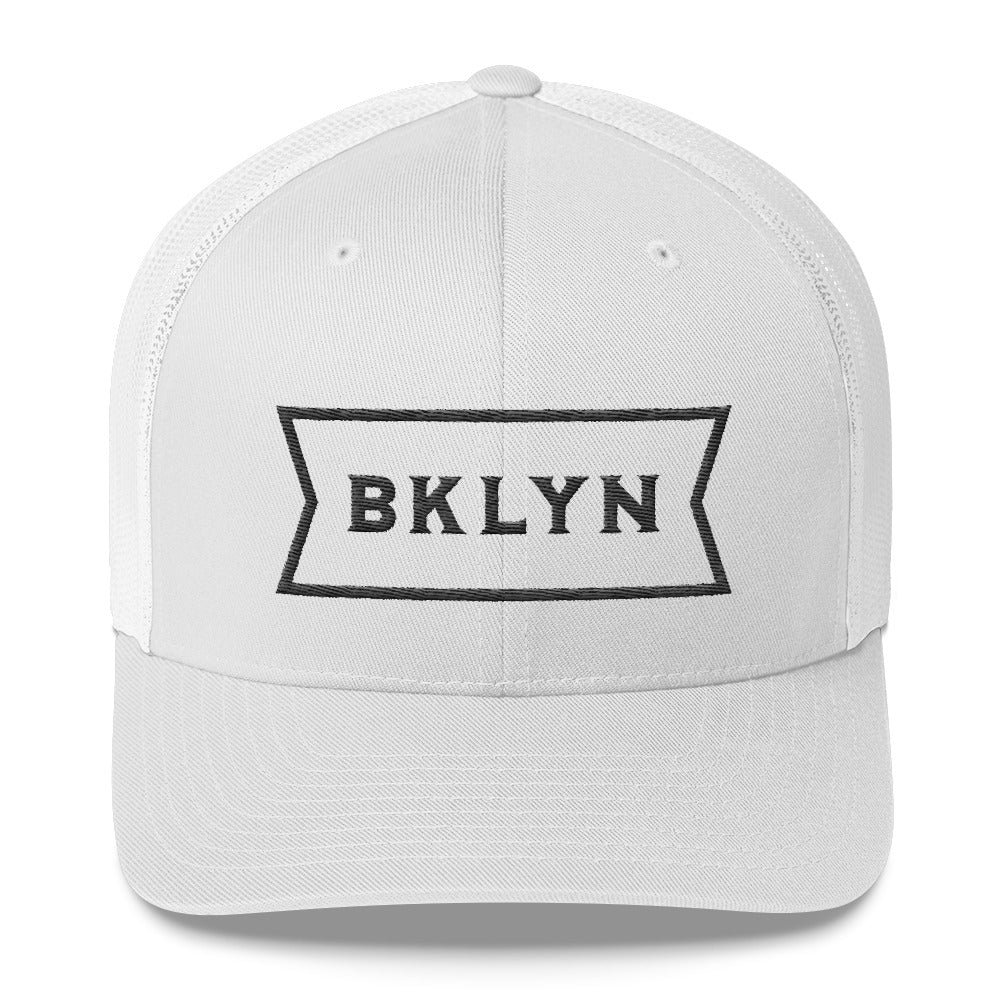 White on White, mesh back classic trucker’s cap, with a strong vintage abbreviated BROOKLYN typographic graphic. From wolfsaint.net 
